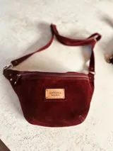 Riñonera de cuero con estampado animal print de vaca en blanco y negro, con correa regulable y cierre superior.