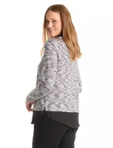 Buzo de tejido fino con efecto melange en tonos tierra, que incorpora cuello y ruedo inferior en tela tipo gasa negra, simulando una camisa debajo. Posee mangas largas y un diseño de corte recto.