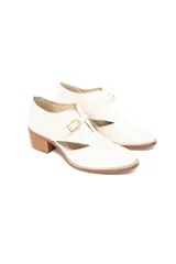 Zapato de cuero color blanco hueso con diseño de texturas combinadas, presentando un acabado tipo reptil en la parte trasera y cuero liso en la puntera. Cuenta con un corte lateral, cierre mediante hebilla dorada y tacón cuadrado de madera.