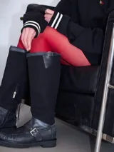 Bota híbrida de caña alta confeccionada en lona negra en la parte superior y cuero negro en la base tipo mocasín, con plataforma, suela track y tira con hebilla metálica cruzada en el empeine.