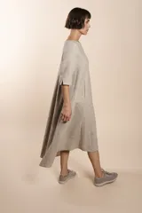 Vestido midi acampanado de lana fina sin teñir, con cuello bote, mangas tres cuartos con tajo y bolsillos laterales. Diseño forrado con vuelo y movimiento.