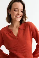 Vestido corto de tejido de punto color beige, manga larga y cuello polo con escote en V.