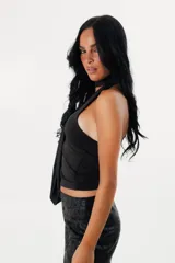 Top halter negro de microfibra, con detalle de tira larga al cuello estilo corbatero y diseño ajustado a la silueta con espalda descubierta.
