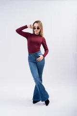 Jean de tiro alto con corte oxford, ajustado en la parte superior y con botamanga acampanada. Presenta un lavado azul clásico con costuras a tono y cierre frontal con botón.