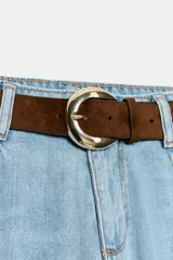 Jeans de tiro alto con pernera ancha y corte cropped. Presenta diseño de cinco bolsillos, cierre frontal con cremallera y botón, e incluye un cinturón de gamuza marrón con hebilla metálica.