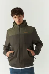 Campera softshell verde con capucha removible, cierre frontal y bolsillos con cierre.