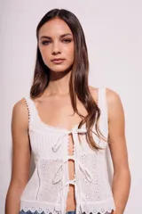 Blusa blanca de algodón con escote cuadrado, breteles anchos con detalle de puntilla y lazos ajustables en el frente.