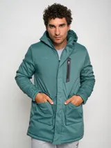 Parka larga gris con capucha, cierre frontal con cremallera y botones a presión, múltiples bolsillos y logo de Umbro en el pecho.