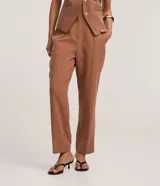 Pantalón de vestir color marrón, de corte recto y tiro alto, con cierre frontal y bolsillos delanteros.