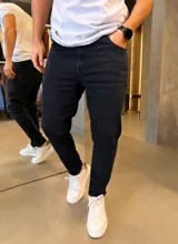 Jean skinny negro de corte ajustado, con elasticidad, bolsillos clásicos y cierre frontal con botón y cremallera.