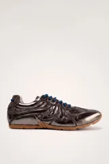 Championes deportivos color marrón con diseño de líneas onduladas en tono claro, cordones al tono y suela de goma.