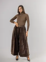 Pantalón tipo palazzo de corte oversized, confeccionado en tela con textura aterciopelada en color negro. Presenta cintura alta con pinzas, bolsillos laterales y un cinturón ancho integrado con hebilla al tono.