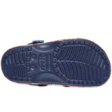Zuecos Crocs Classic Clog inspirados en Disney Lilo & Stitch, de color celeste en la parte superior con estampado de Stitch y adornos Jibbitz exclusivos, y suela roja con estampado de hojas tropicales.
