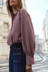Camisa corta de manga larga con cuello solapa, confeccionada en tela con estampado de cuadros vichy en color bordó y blanco. Presenta un bolsillo delantero de plastrón, cierre frontal con botones y bajo abullonado con elástico interior.