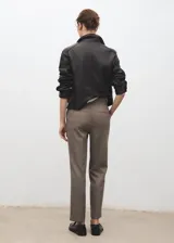Pantalón de tiro medio color marrón con sutil diseño de raya diplomática, de corte entallado y diseño crop. Cuenta con bolsillos laterales, trabillas y cierre frontal con cremallera, botón y ganchos ocultos.