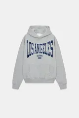 Sudadera gris con capucha y manga larga. Presenta un bolsillo canguro en la parte delantera y un estampado en azul marino con el texto "LOS ANGELES CALIFORNIA EST. 1975". Los acabados son de rib.