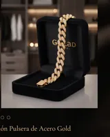 Pulsera tipo cadena cubana de acero con baño de oro, adornada con engarces de micropave de circonias en cada eslabón y en el cierre central.