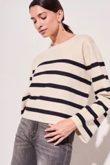 Sweater de punto con diseño a rayas horizontales en color crema y marrón, de corte holgado, cuello redondo y mangas largas acampanadas.