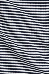 Vestido midi de punto acanalado a rayas horizontales blancas y negras, de manga larga, corte ajustado, escote redondo y espalda en U. Tiene tajo lateral.