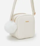 Cartera bandolera Satinato pequeña de color blanco, de diseño estructurado con textura floater, cierre de cremallera y detalles metálicos dorados. Incluye una correa larga ajustable y un pompón decorativo colgante.