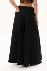 Pantalón de tiro medio con corte súper acampanado, confeccionado en gabardina con spandex. Presenta bolsillos delanteros y traseros, con cierre frontal de cremallera y botón.