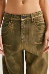Jean slouchy de tiro alto, color verde militar con efecto desgastado, de corte relajado y silueta barrel con piernas curvadas y botamangas ajustadas.