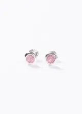 Par de aros tipo stud (perno) de plata 925, con engaste biselado y una piedra de circonia redonda de color rosa claro en el centro.