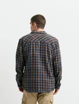 Sobrecamisa de manga larga con diseño a cuadros, cuello camisero y bolsillos laterales. Presenta un interior forrado con textura símil corderito y cierre frontal con botones.