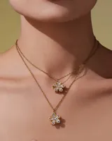 Collar de acero quirúrgico con baño de oro 18k, compuesto por una cadena fina y un dije en forma de flor adornado con circonias.