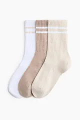 Pack de tres pares de medias deportivas de caña media, confeccionadas en tejido acanalado con dos líneas horizontales en contraste en la parte superior. Incluye un par blanco, uno marrón y uno beige.
