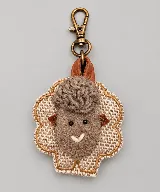 Llavero artesanal con diseño de ovejita, elaborado con tejido de punto texturizado y detalles en lana y cuero, con gancho metálico de bronce.