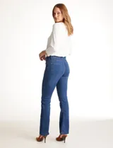 Jean de tiro alto con corte bootcut, ajustado en cadera y muslos con una sutil apertura desde la rodilla. Presenta diseño clásico de cinco bolsillos, cierre con botón y costuras en contraste. Su diseño posterior incluye costuras estratégicas para un efecto de realce en la silueta.