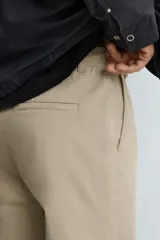 Pantalón de corte recto confeccionado en tejido de sarga con estructura diagonal. Presenta cintura elástica, bolsillos delanteros, bolsillos traseros de vivo y cierre frontal con cremallera y botón.