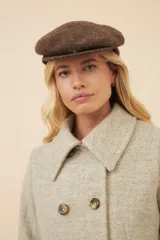 Boina con visera de lana fina uruguaya natural, sin teñir, con diseño de tejido texturizado en tonos beige y marrón.