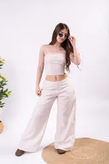 Top strapless de tejido liviano y texturado color beige, con ajuste al cuerpo.