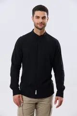 Camisa de lino y algodón color blanco, con cuello mao, manga larga y cierre frontal de botones. Presenta un pequeño logo bordado en el pecho.