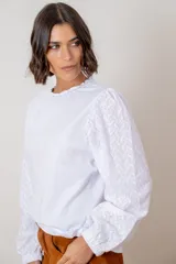 Remera de algodón color azul marino, con cuello redondo fruncido y mangas largas abullonadas con puños elásticos.