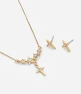 Conjunto de bisutería compuesto por un collar de cadena fina con dije central de estrellas y cruz con aplicación de strass, y un par de aros tipo caravana con diseño de cruz y strass.