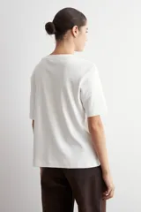 Remera de corte oversized, color verde oliva, con cuello redondo y mangas cortas.