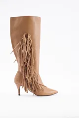 Bota de caña alta confeccionada en cuero vacuno color suela, con diseño de flecos laterales y taco fino.