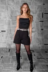 Short negro de tiro alto confeccionado en tela sastrera liviana con micro apliques de strass distribuidos de manera uniforme. Corte holgado con pinzas delanteras.