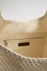 Bolso tipo shopper de tejido de algodón color beige, con diseño de red exterior y compartimento principal con cierre de imán. Cuenta con asa de mano oscura a contraste y bolsillos interiores.