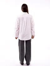 Camisa blanca a rayas verticales color ladrillo, de corte recto y mangas largas con puños abotonados.