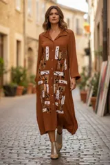 Vestido camisero midi de color marrón terracota, de manga larga, cuello solapa y cierre frontal con botones. Presenta un diseño estampado de estilo artístico abstracto en la parte frontal.