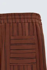 Bermuda de corte relajado color marrón con finas rayas verticales negras. Presenta cintura elástica ajustable con cordón y bolsillos laterales y trasero.
