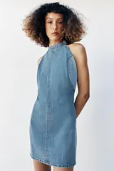 Vestido corto de denim con cuello halter, espalda descubierta y diseño de lavado combinado en tonos de azul.