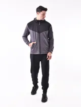 Campera deportiva con cierre frontal, capucha y diseño de bloques de color. La parte superior (hombros y capucha) es negra, y el cuerpo y mangas son de color azul vibrante, con un corte diagonal que separa ambos colores.