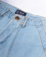 Bermuda de jean celeste con dos bolsillos frontales tipo parche, costuras a contratono y botones de cobre.