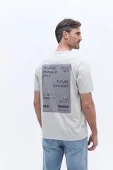 Remera de manga corta color gris claro con cuello redondo y calce regular. Presenta un diseño gráfico estampado en la espalda con tipografía moderna y detalles minimalistas.