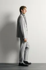 Pantalón de traje slim fit color gris, con bolsillos frontales, bolsillos traseros de doble vivo, trabillas para cinturón y cierre frontal con cremallera y botón.